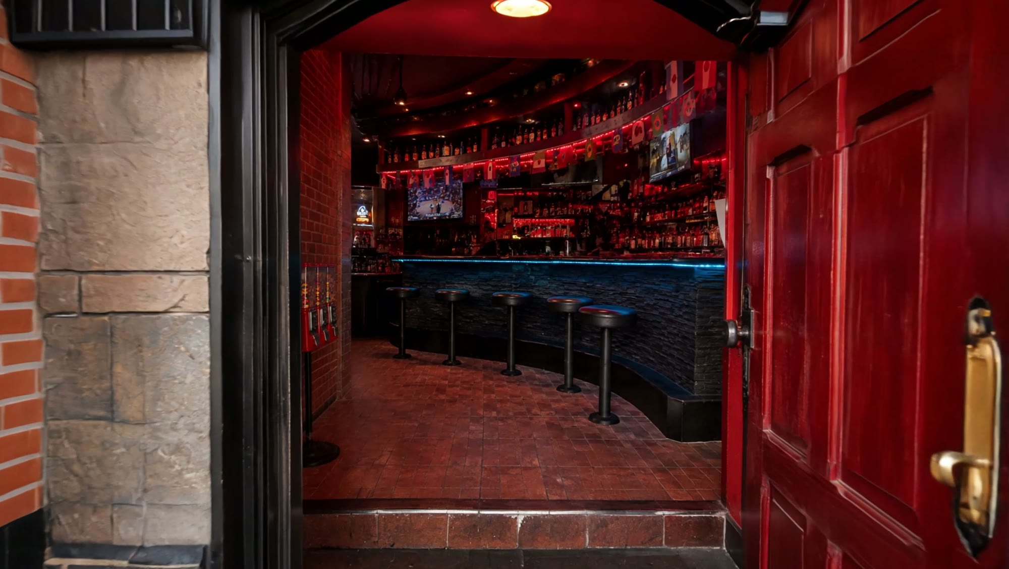 The red-lit bar inside El Chavocho — curved stone counter with blue LED glow, bar stools, liquor shelves and a game on the TV