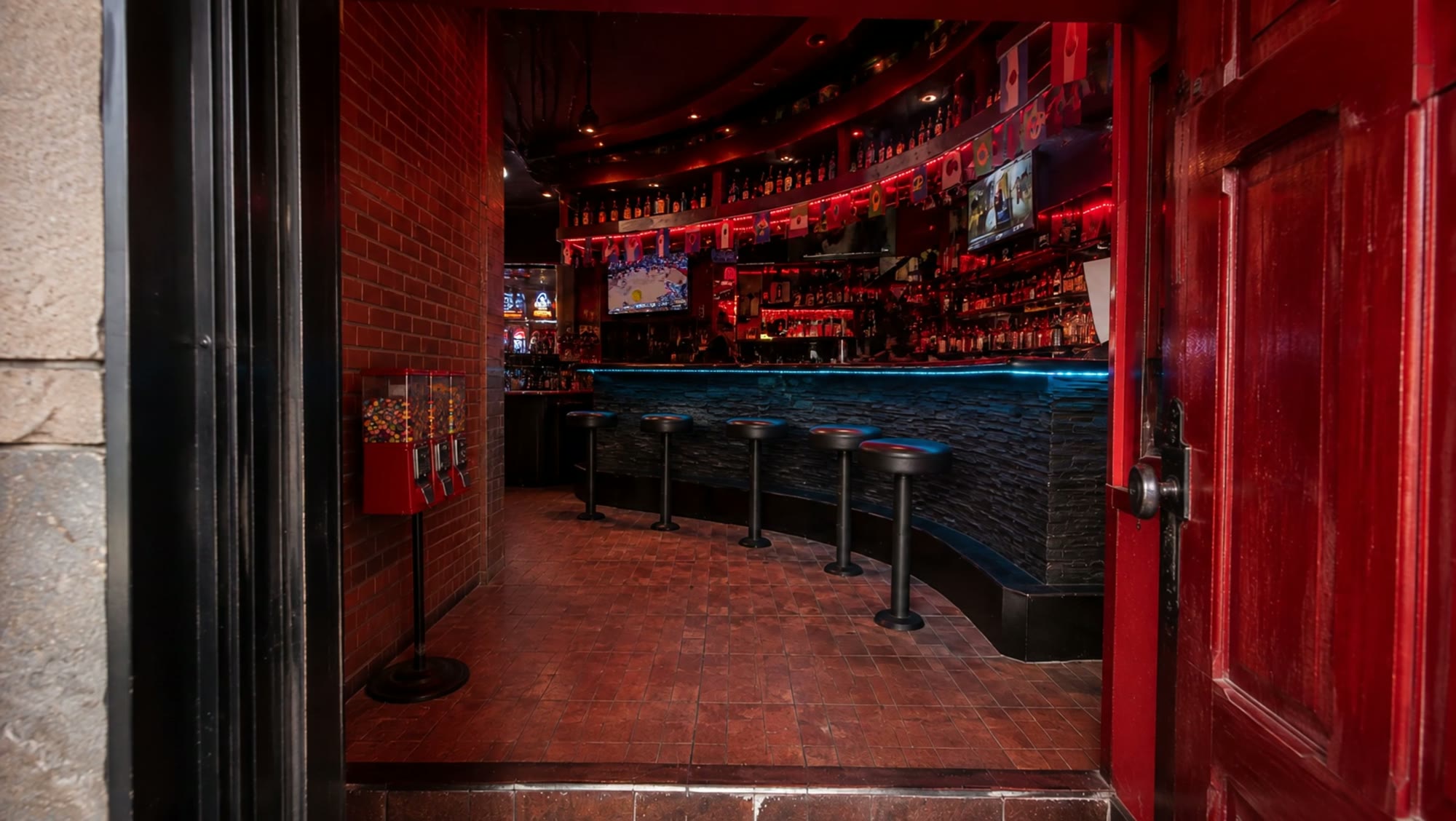 Bar stools lining the curved counter under red interior lighting at El Chavocho